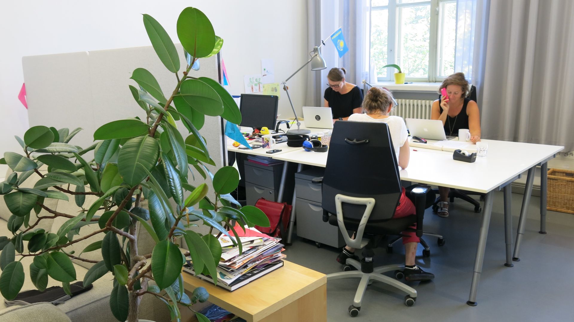 Bild på DuvTeaterns kontor. Tre personer av personalen sitter och arbetar vid arbetsbord.