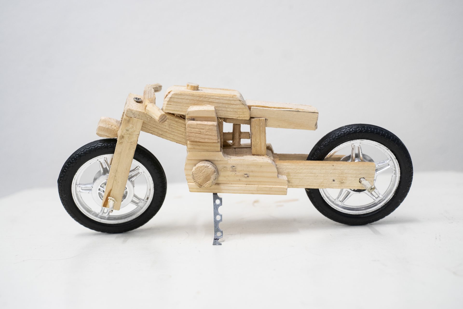 Foto av motorcykel tillverkad i trä med gummihjul.